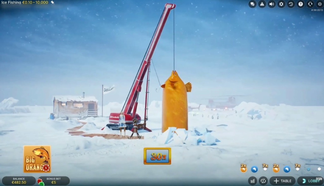 Ice Fishing Big Oranges bonus moment with large orange fish lifted by crane